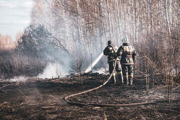 a brave firefighter puts out a grass fire in the villages close to the metropolis with the help of...