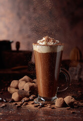 Truffles and glass of hot chocolate with whipped cream.