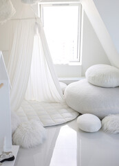 Large pillows for relaxing and a white teepee tent with a mat. Cozy nursery on the attic floor....