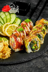 Sushi roll set with avocado, tuna, eel on black slate on dark background