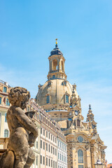Fototapeta premium Church of Our Lady at Neumarkt square in downtown of Dresden in summer sunny day with blue sky copy space, Germany, and a statue of a child in foreground.