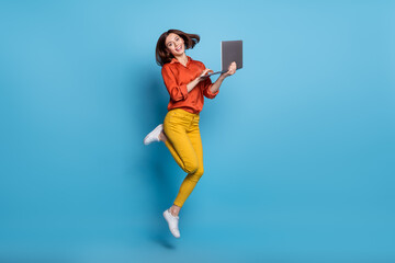 Full size profile side photo of young excited girl energetic jump use laptop manager isolated over blue color background