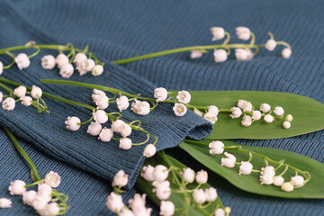 knitted sweater and a bouquet of fresh lilies of the valley. concept for dry cleaning and washing...
