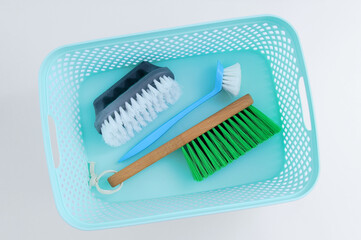 Three cleaning brushes with handle in a plastic box. White background.