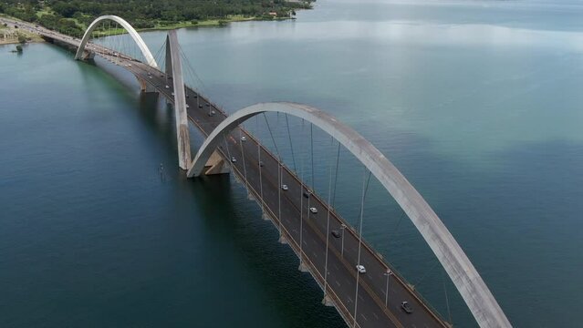 Aerial tilt down shot showing traffic on JK Bridge (Portuguese: Ponte JK ), a steel and concrete arch bridge across Lake Paranoa in Brasilia, Federal District, capital of Brazil.	
