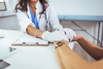 Closeup shot of an unrecognizable female doctor holding a patient's hand in comfort during a consultation inside her office. Cropped shot of a senior woman holding hands with a nurse
