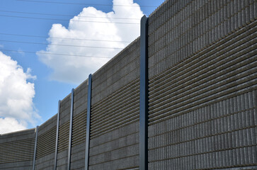 soundproof wall made of concrete porous ribbed material. fence of brown blocks inserted into metal beams, on the street. noise from road traffic does not get into the garden and residential area.