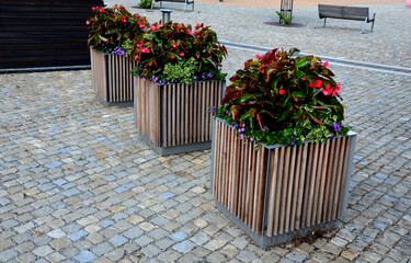 ornamental flower pots on village center trough, wooden flower pots with beautiful decorations of...
