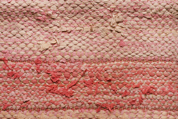 Rag rug close up. Recycled fabric. Pink, white weaved texture Traditional recycled scandinavian carpet. Background. Wallpaper