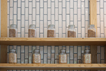 Obraz na płótnie Canvas different roast coffee in glass jars on wooden shelf.