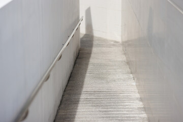 Fototapeta na wymiar A concrete wheelchair ramp. path way for support wheelchair disabled with stainless steel handrail.