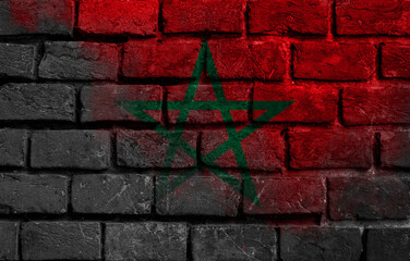 Close-up on a brick wall with the flag of Morocco painted on it.