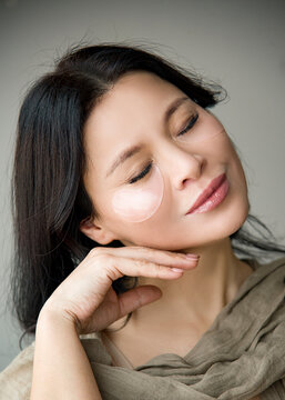 portrait of  asian beautiful woman with transparent patch under eye relaxing with close eyes in spa salon