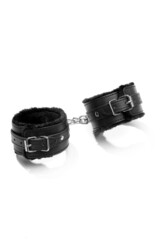 Close-up shot of black leather shackles for hands or legs and for usage in sexual games. The black...