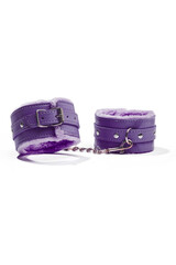 Close-up shot of purple leather shackles for hands or legs and for usage in sexual games. The...