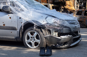 Shot, damaged cars during the war in Ukraine. The vehicle of civilians affected by the hands of the Russian military. Shrapnel and bullet holes in the body of the car. War of Russia against Ukraine.