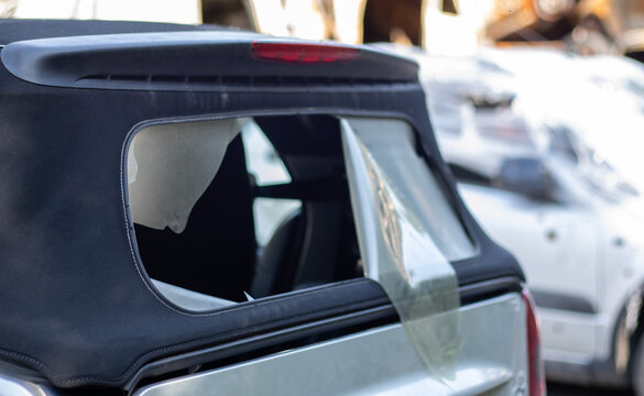 Damaged Roof Material On The Back Of The Convertible. Vandalism, Thieves Cut The Roof Of A Convertible From Behind. Theft Of Things From The Car. Criminal Incident. Car Burglary.