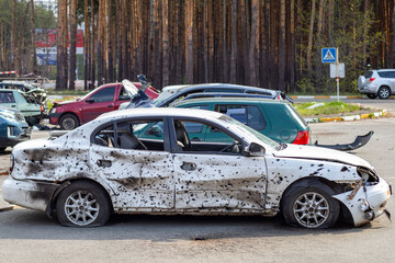 A car destroyed by shrapnel from a rocket that exploded nearby. Irpensky automobile cemetery. Consequences of the invasion of the Russian army in Ukraine. Destroyed civilian vehicle.