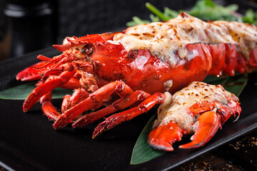 grilled lobster lobster meat on black plate with arugula leaves