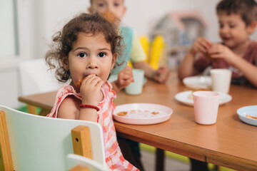 cute young girl breakfast in kindergarden - obrazy, fototapety, plakaty