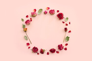 top view of dry rose flowers over pink pastel background with copy space