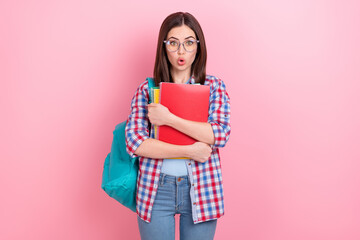 Photo of impressed good mood lady excited to pass exam hold many copybooks isolated on pink color background