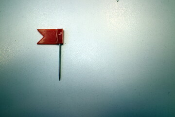 red flag with needles on the office table