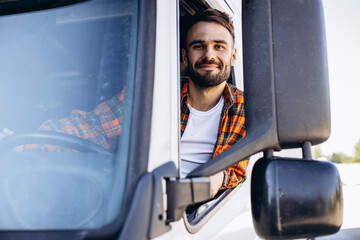 Man trucker sitting in a cabin and looking through the window