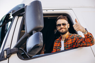 Man trucker sitting in a cabin and looking through the window