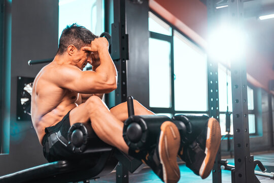 Middle aged man workout in fitness club. Closeup portrait of caucasian guy making exercise, sit-ups and cross crunches for abs muscles, training indoors.