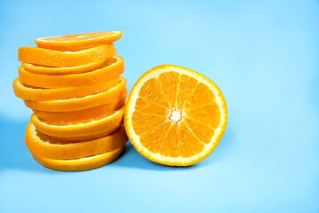 Fototapeta na wymiar Summer composition with fresh orange slices on a bright blue background. sliced ​​orange