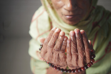 Close up of senior women hand praying at ramadan 