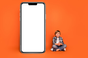 Full size photo of young boy sit floor promotion panel menu website isolated over orange color background