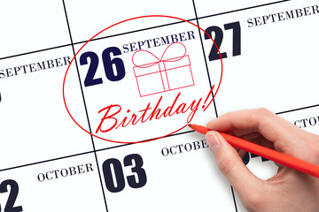 The hand circles the date on the calendar 26 September , draws a gift box and writes the text Birthday. Holiday.