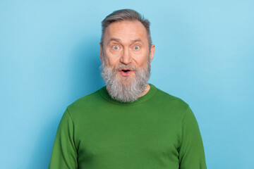 Obraz premium Portrait of astonished mature man look listen incredible novelty message wear pullover isolated blue color background