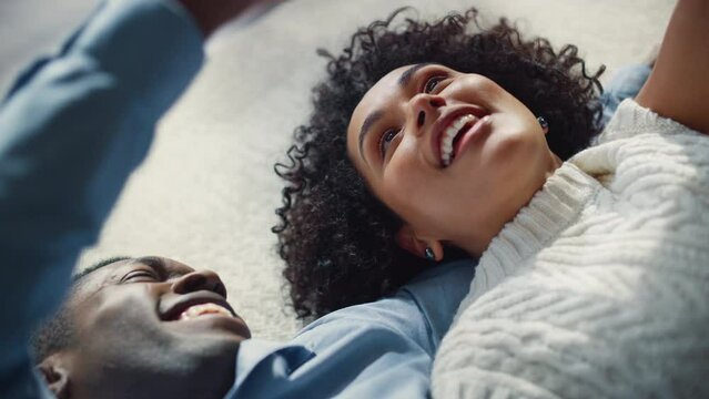 Love and Tenderness with Passion for African American Couple Laying on the Floor and Enjoying Relationship. Young Boyfriend and Girlfriend Laugh and Playing with Hands of Each Other. Slow Mo