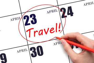 Hand drawing a red circle and writing the text TRAVEL on the calendar date 23 April. Travel...