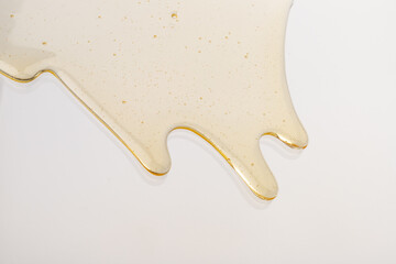 Fototapeta premium Honey flows. Drops of yellow syrup flow. Natural product and sweet drink. Isolated on white background.