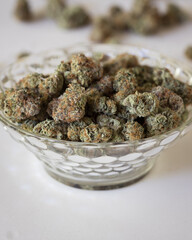 Dried and trimmed cannabis buds. Green marijuana buds with light natural background