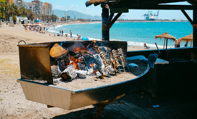 cooking espetos in La Malagueta beach in Malaga, Spain