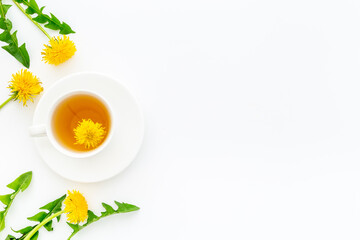 Cup of healing herbal tea with yellow dandelions flowers