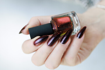 Female hands with long nails and black and red nail polish