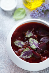 Close-up of a white bowl with borsch or soup made of red beetroots and meat, vertical shot
