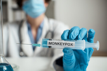 Doctor in mask, white coat holds syringe inscription Smallpox. Monkeypox is virus transmitted to...