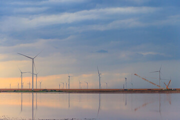 Fototapeta premium Building and assembling a construction wind turbines farm by a crane