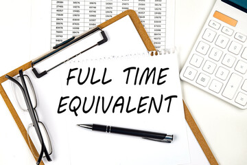 Text FULL TIME EQUIVALENT on the white paper on clipboard with chart and calculator