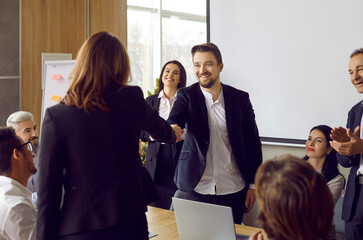 Smiling diverse businesspeople shake hands get acquainted at meeting in office. Business clients or partners handshake close deal or make agreement after successful negotiations. Collaboration.