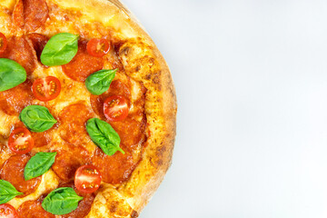 Top view of half of delicious pepperoni pizza with salami and tomatoes on light background