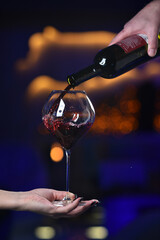 Sommelier pouring red wine into a glass
