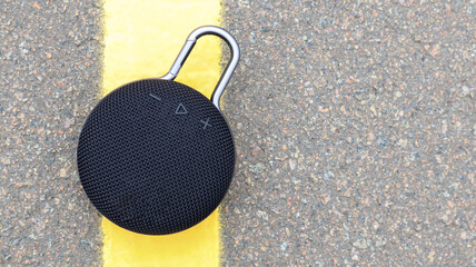 Waterproof round black Bluetooth speaker with carabiner. Digital music and audio concept. Mini,...